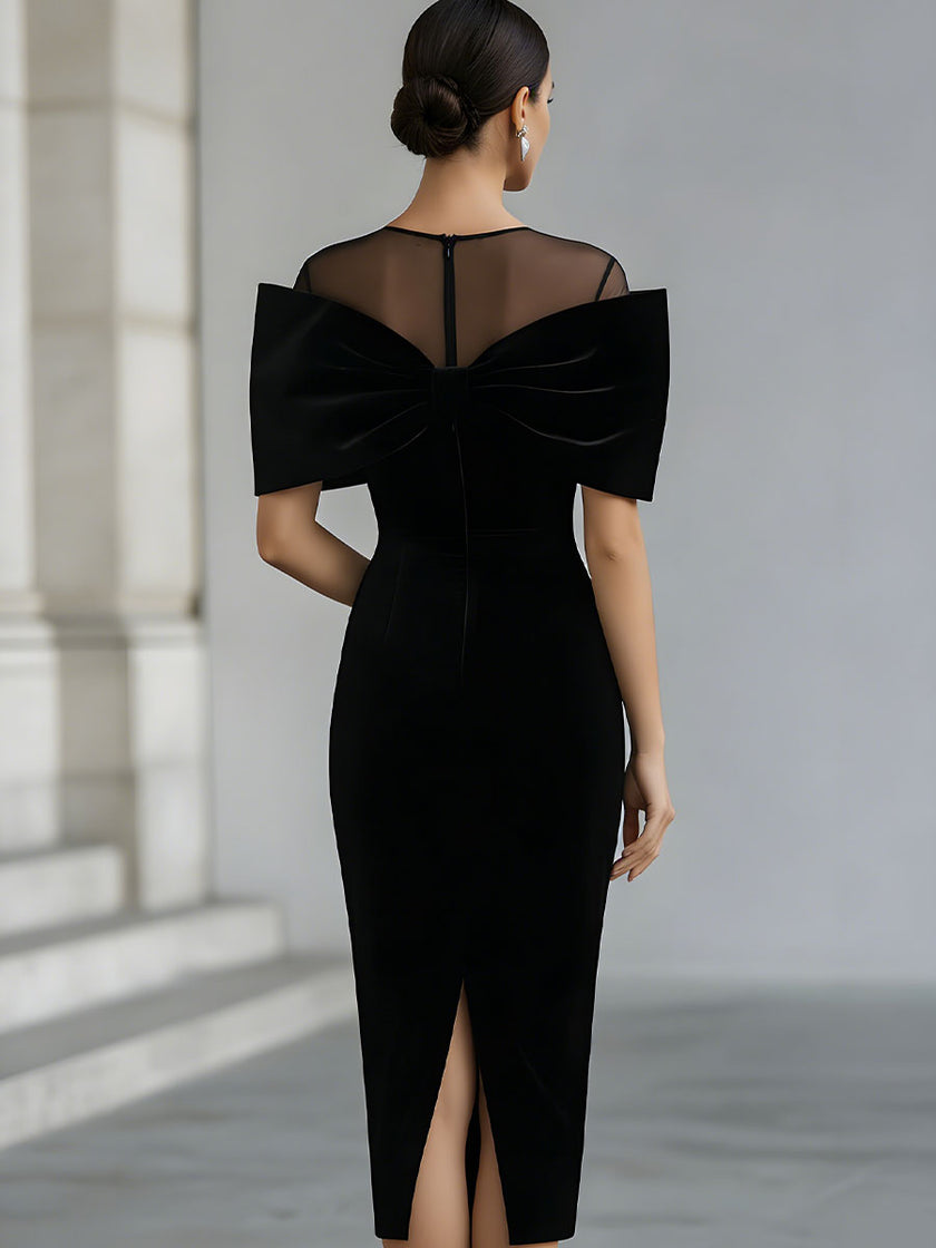 FJØRNA black velvet midi dress for women with a dramatic bow detail, elegant midi length, and fitted silhouette.