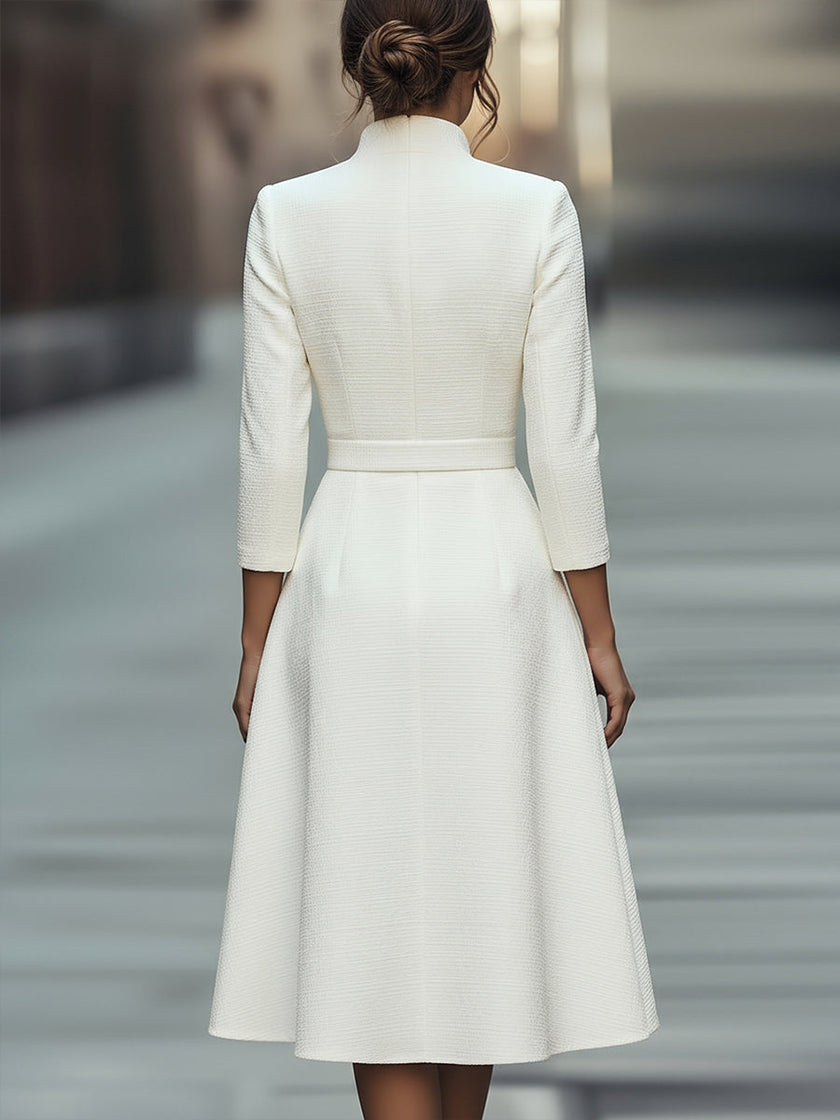 White textured belted midi dress with V-neckline by FJØRNA, featuring a flowing silhouette and stylish waist tie.