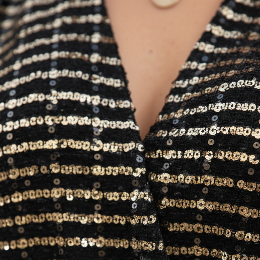 FJØRNA glitter long sleeve top for women, showcasing a shiny, stylish design with a fitted silhouette and long sleeves.