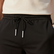 Men's FJØRNA trousers, stylish pants with a relaxed fit, shown in a neutral fabric with a modern, casual design.