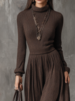 FJØRNA retro high-neck long-sleeved ribbed knitted midi dress displayed on a hanger, showcasing its textured fabric and classic silhouette.