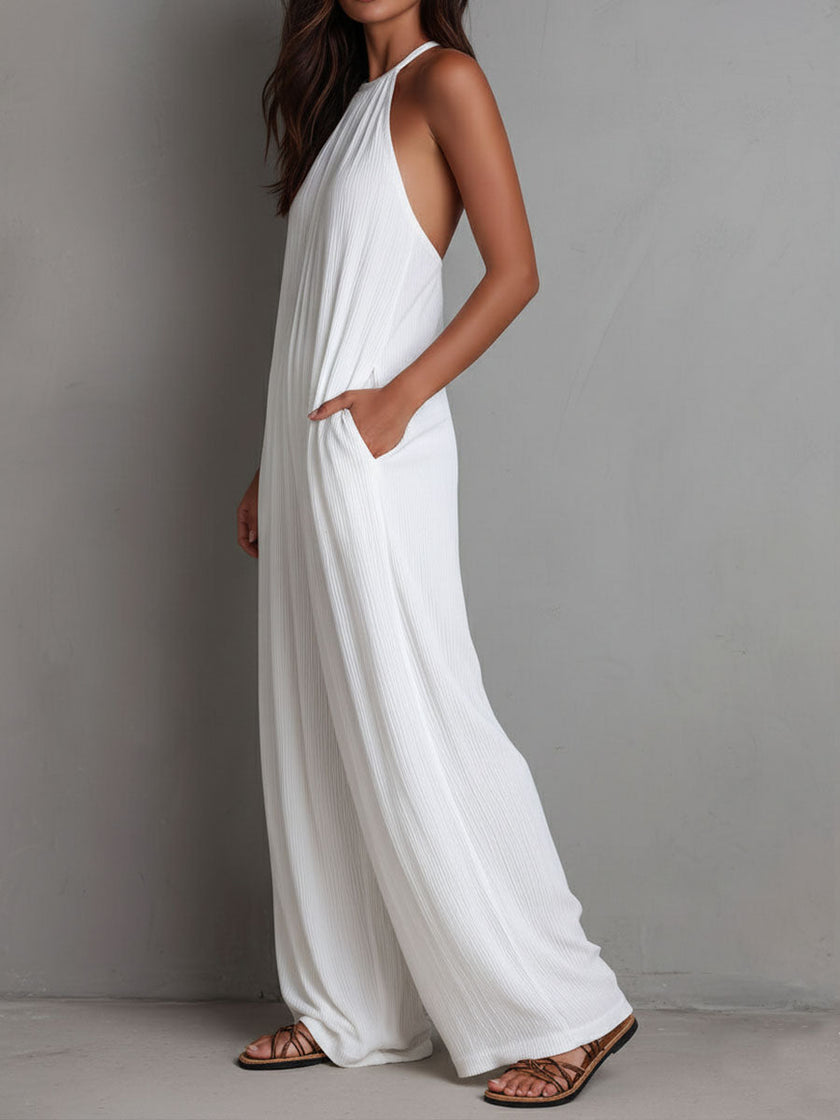 White pleated halter neck wide-leg resort jumpsuit by FJØRNA, featuring a stylish halter top and flowing wide-leg design.