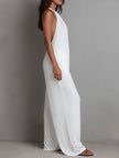 White pleated halter neck wide-leg resort jumpsuit by FJØRNA, featuring flowing fabric and stylish design, displayed on a mannequin.