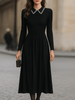 FJØRNA black long-sleeve midi dress with embellished collar, featuring a sleek silhouette and stylish design.