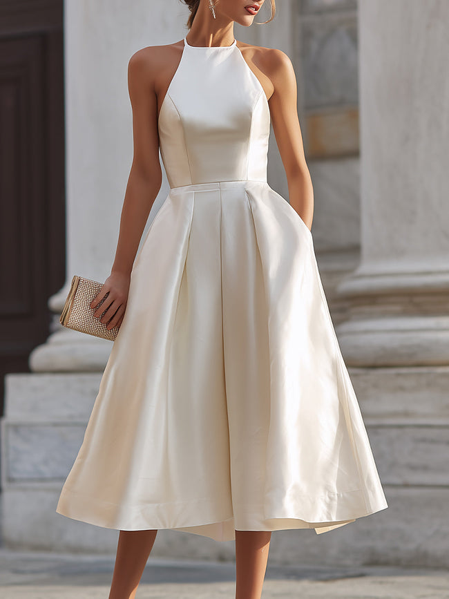 FJØRNA halter-neck pleated midi dress for women, featuring a flowing silhouette and elegant pleated design.