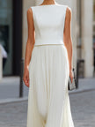 FJØRNA sleeveless boat neck pleated maxi dress in flowing fabric with a fitted waist and elegant design.