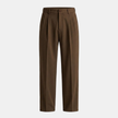 FJØRNA men's pleated relaxed fit pants with a classic trousers design and tailored waistband, shown on a model.