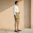 Men's high waist linen shorts with pleats by FJØRNA, featuring a relaxed fit and casual style, shown on a model.