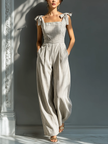 FJØRNA women's striped linen-blend jumpsuit with square neck, tie straps, and wide-leg pants, shown from the front.