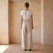 FJØRNA women's linen wide-leg trousers with high waist and tailored fit, shown in natural beige fabric.