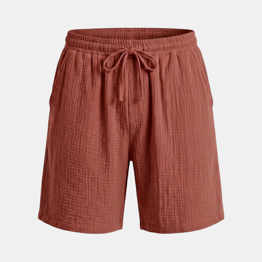 FJØRNA men's relaxed fit drawstring shorts with casual style, shown on a model, in neutral fabric with side pockets.
