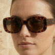 FJØRNA retro rectangular unisex sunglasses with black frames and dark lenses, stylish accessories for women and men.