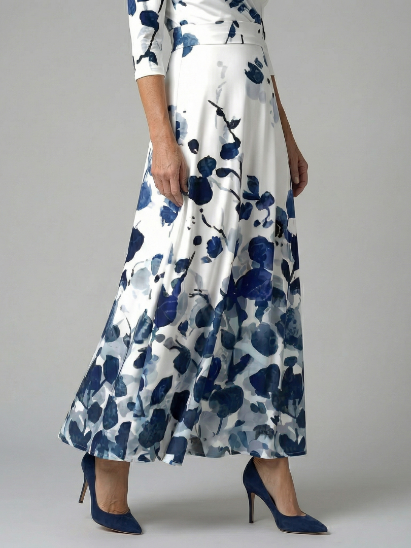 FJØRNA women's floral summer maxi dress with V-neck and wrap design, flowing fabric and vibrant floral pattern.