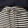 FJØRNA women's striped drawstring trousers, casual pants with relaxed fit and adjustable waist, shown with side view.