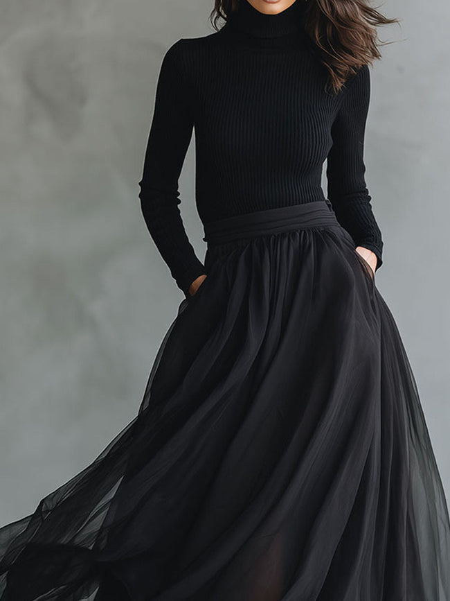 Elegant black tulle maxi dress by FJØRNA featuring patchwork design and fitted knit silhouette, flowing and sophisticated.