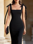 FJØRNA bow-shoulder square-neck evening dress for women, elegant black dress with puffed sleeves and fitted silhouette.