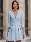 Elegant powder blue pleated fit-and-flare dress by FJØRNA, showcasing a flowing skirt and fitted bodice for women.