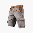 Men's FJØRNA cargo shorts with multiple functional pockets and ample storage, shown on a model with casual outdoor setting.