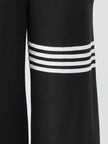 Black striped sleeveless hooded jumpsuit by FJØRNA, featuring a relaxed fit and stylish design, shown on a model.