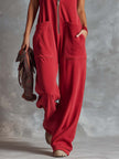 Raspberry red cotton hooded zip-front jumpsuit by FJØRNA, featuring a relaxed fit and front zipper detail.