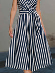 FJØRNA sleeveless wrap-style midi dress with vertical stripe pattern, showcasing a fitted waist and flowing skirt.