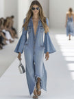 Light blue denim flared long sleeve jumpsuit by FJØRNA featuring wide-leg silhouette and button-up front.