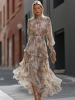 FJØRNA high neck tiered floral maxi dress with long sleeves and ruffled layers, featuring a vibrant floral pattern.