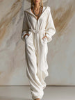 White corduroy hooded zip-front jumpsuit by FJØRNA with long sleeves, featuring a casual, stylish design.