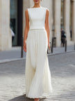 FJØRNA sleeveless boat neck pleated maxi dress with flowing fabric and elegant design, perfect for summer or formal occasions.
