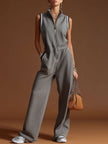 Dark grey FJØRNA cotton blend sleeveless zip-up jumpsuit displayed on a hanger, showing its fitted design and casual style.