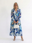 FJØRNA elegant floral maxi dress for women with long sleeves, featuring a flowing design and vibrant floral pattern.