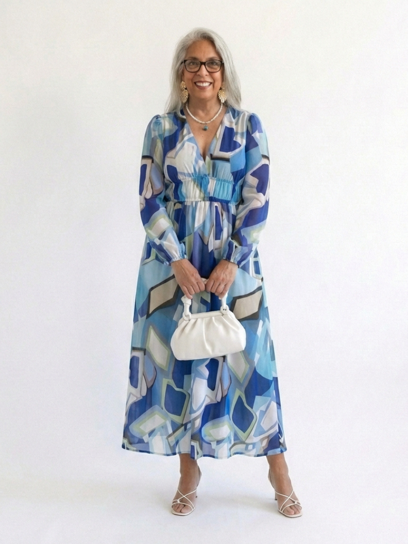 FJØRNA elegant floral maxi dress for women with long sleeves, featuring a flowing design and vibrant floral pattern.