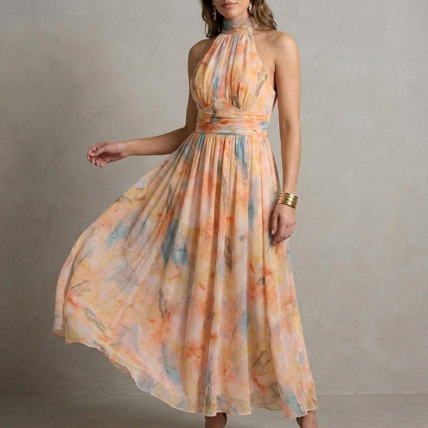 FJØRNA Ariellea flowing chiffon halter neck maxi dress with waist tie, shown from a side angle highlighting its elegant design.