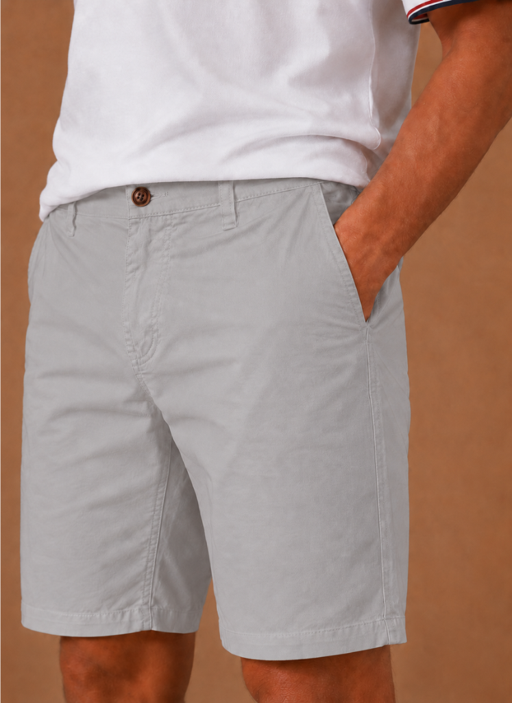 Men's FJØRNA chino shorts in cotton blend, tailored fit, smart casual style, shown in a natural stance with front pockets and rolled hems.