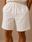 Men's linen drawstring shorts by FJØRNA featuring a relaxed fit with white and striped pattern, casual and comfortable men's pants.