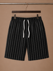 Men's linen drawstring shorts by FJØRNA with relaxed fit and white striped pattern, casual and breathable for summer wear.