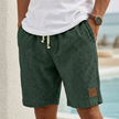 Men's army green casual drawstring shorts with pockets and elegant accents by FJØRNA, suitable for relaxed summer wear.