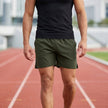 Men's Army Green athletic shorts by FJØRNA with elastic waistband and side slits, designed for comfort and active wear.