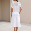 FJØRNA flowing midi dress and cropped open-knit mesh top set, back view showing the elegant drape and textured fabric details.