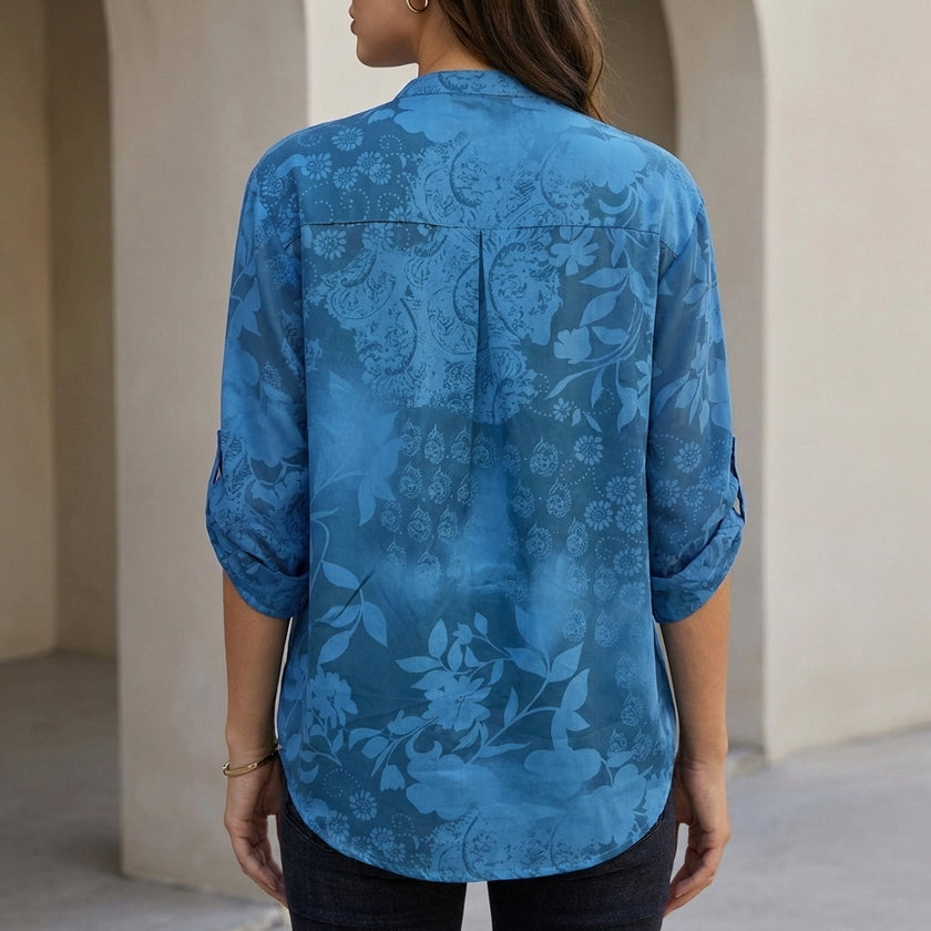 Back view of FJØRNA women's summer floral V-neck denim blouse, showing detailed stitching and relaxed fit.