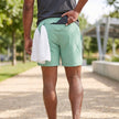 Men's FJØRNA athletic shorts with adjustable waist, pockets, and performance woven fabric, shown from the back.