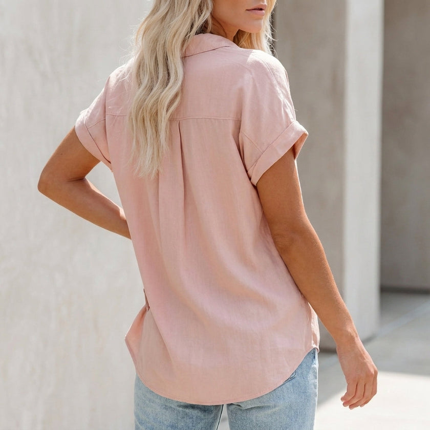 FJØRNA women's collared button-up blouse with cuffed sleeves and chest pocket, shown from the back with detailed cuff and seam work.