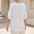 Back view of FJØRNA women's floral V-neck linen summer blouse with flowing fit and floral pattern.