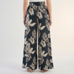 Back view of FJØRNA women's summer cotton trousers with ruched design, showcasing relaxed fit and comfortable fabric.