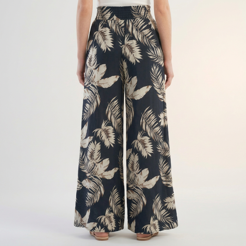 Back view of FJØRNA women's summer cotton trousers with ruched design, showcasing relaxed fit and comfortable fabric.
