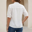 Back view of FJØRNA elegant relaxed fit women's V-neck blouse with embroidered floral details.