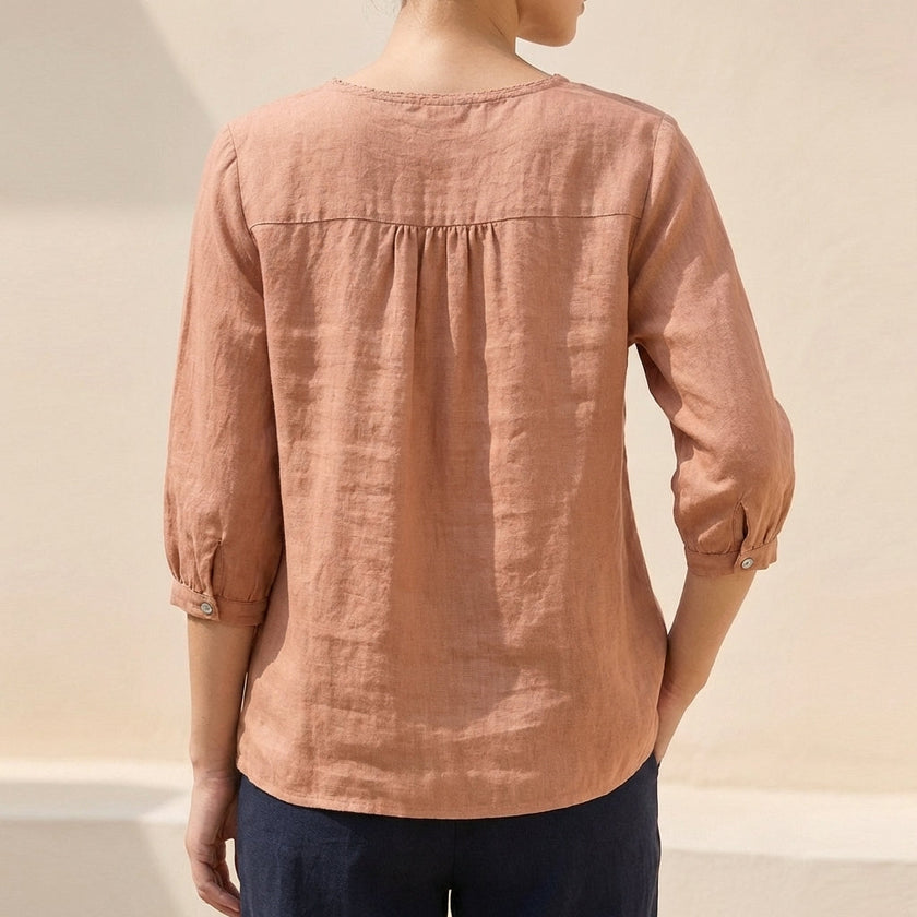 Back view of FJØRNA women's floral cotton summer blouse with lightweight, feminine design and delicate floral pattern.