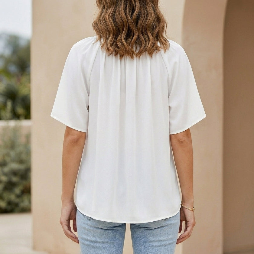 Back view of FJØRNA women's summer blouse with v-neck and flutter sleeves, lightweight and stylish for warm weather.