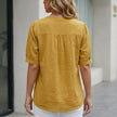 FJØRNA women's summer linen blouse with short sleeves and front pockets, shown from the back. Light, breathable fabric.