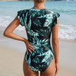 FJØRNA women's summer one-piece swimsuit with ruffle and ruched design, shown from the back in a stylish swimwear image.